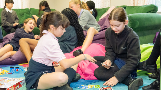 Windlesham House boarding pupils, surrounded by bean bags and soft furnishings, playing games in the boarding house